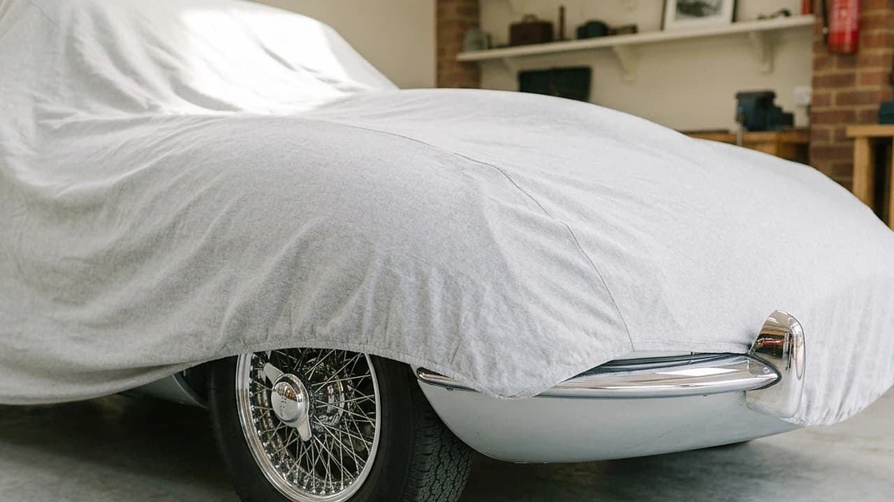Auto d'epoca ferma sotto un telo in un garage luminoso, bollo auto non circolante 2026
